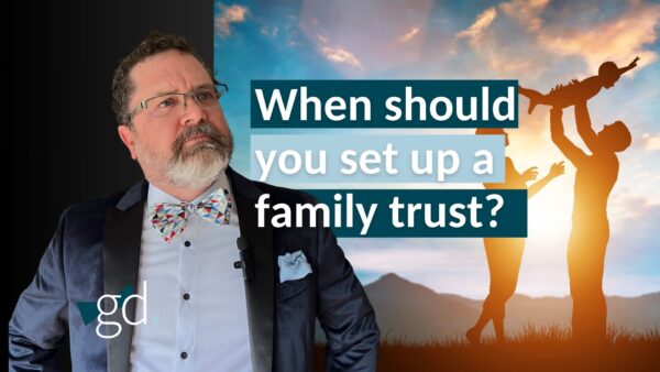 Bearded man in glasses with a suit jacket and bow tie next to a family swinging a child, and the title: "When should you set up a family trust?"